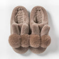 Women's fluffy high-top rabbit fur slippers in cream colour on a wooden floor.