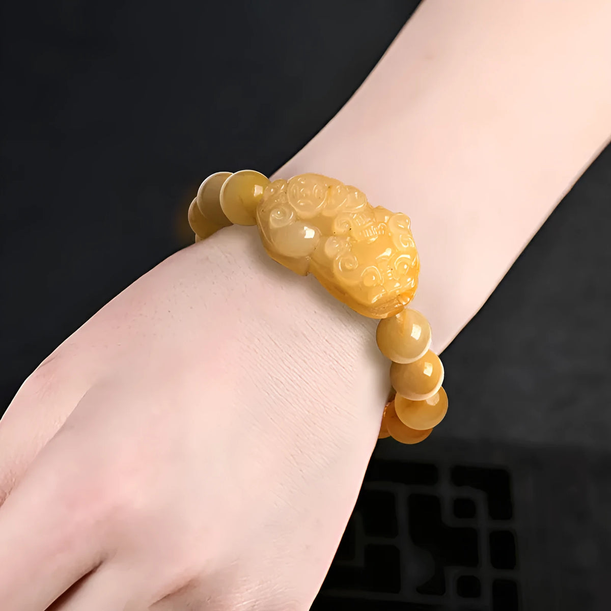 Hand-carved Golden Thread Jade money bracelet showing detailed coin design on round jade beads.