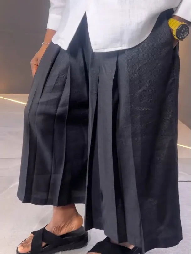 White asymmetric long sleeve shirt paired with black pleated pants in a women's casual two-piece set.