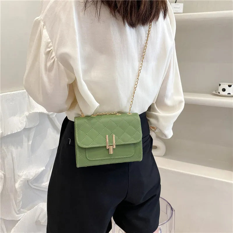 Women's black PU leather crossbody bag with diamond lattice chain detailing and adjustable shoulder strap