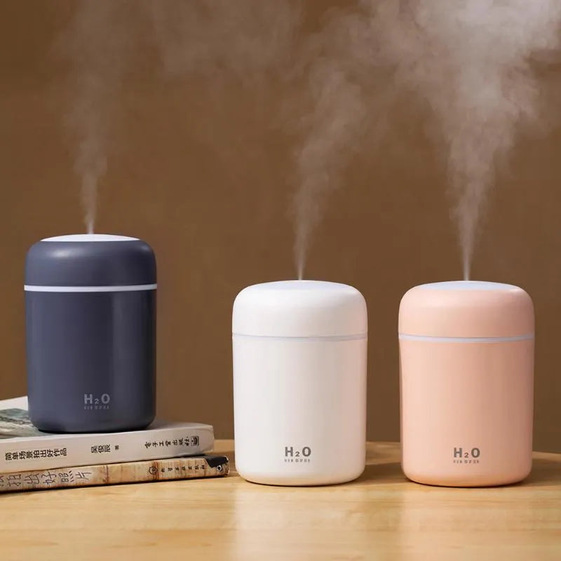 Pink USB portable humidifier with 300ml tank and colourful lights on a desk