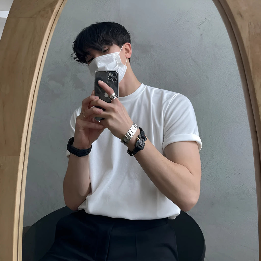Men's slim fit solid colour cotton t-shirt on a model, showing round neck and half sleeves in white or black.