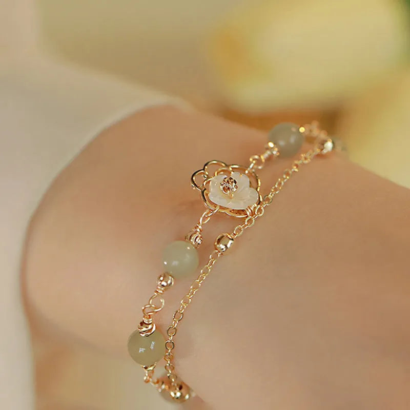 Women's yellow gold electroplated copper butterfly bracelet with geometric shell flower design and Hetian jade stone.