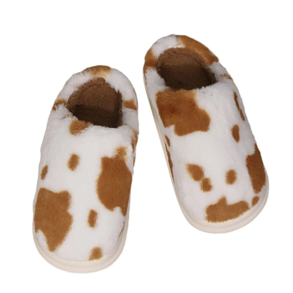 Cow spotted plush slippers in brown with round toe and baotou style on a home floor