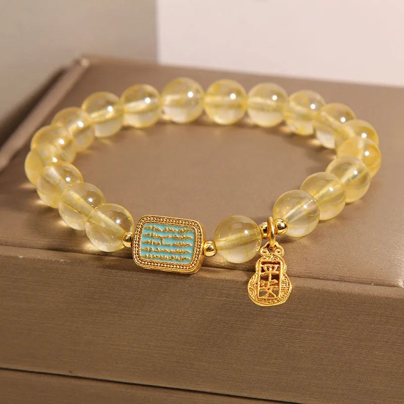 Women's yellow citrine crystal bracelet with sparkling rhinestone details on wrist.