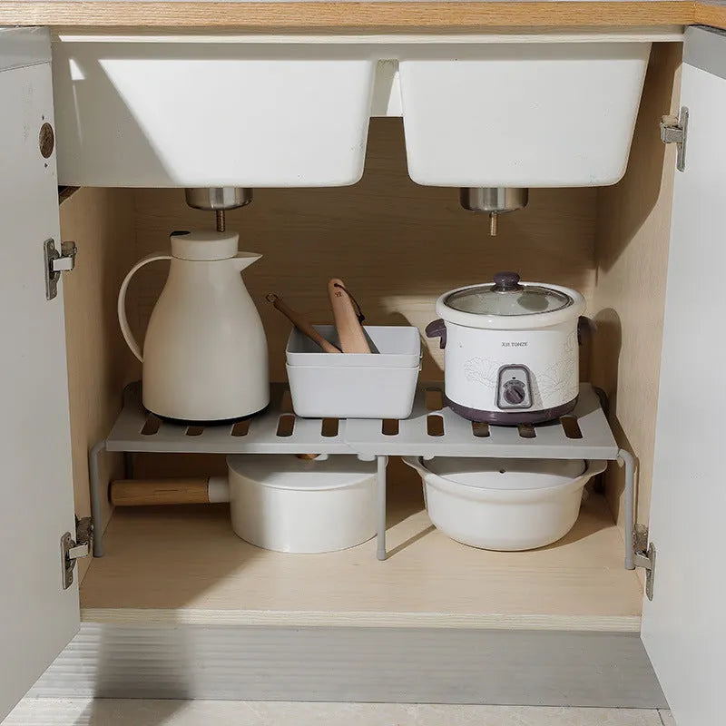 White telescopic plastic kitchen rack extended to 69cm height on kitchen countertop
