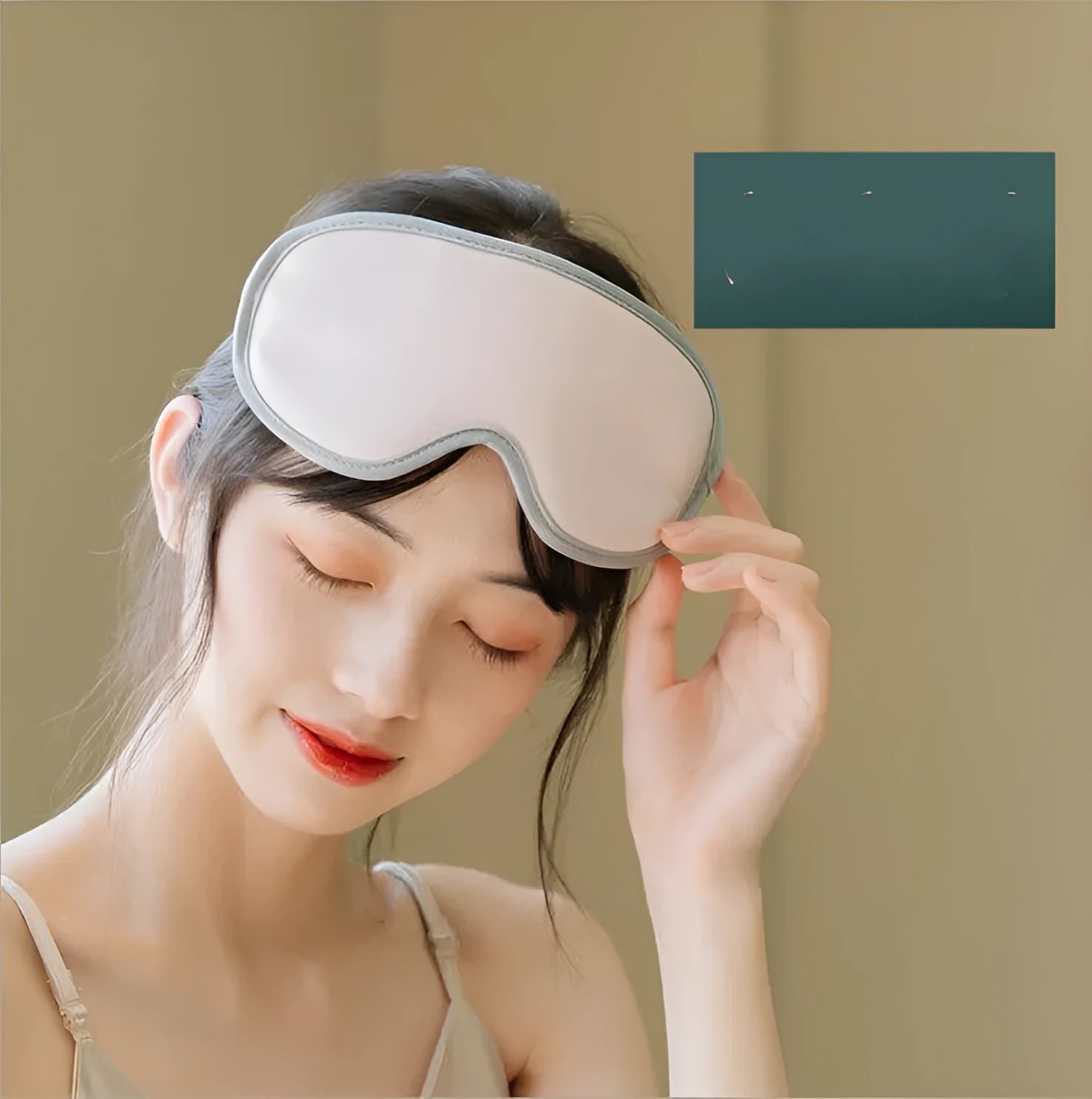 Green portable USB eye spa mask showing suede shell and super fibre interior on a desk.