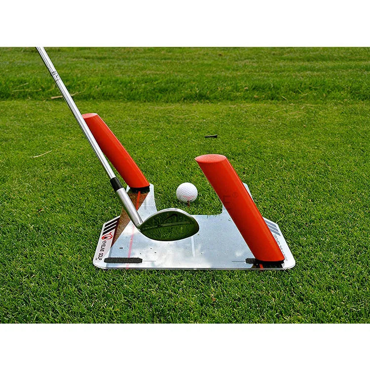Red plastic putting practice mirror for golf alignment training on grass