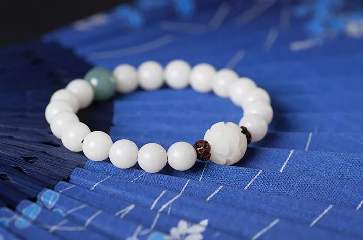 Natural white jade Bodhi bracelet with transfer beads on a neutral background