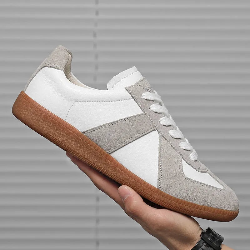 White low-top retro sneakers with mesh lining and rubber soles on a solid background