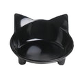 Shallow black melamine cat bowl with non-slip rubber base on a wooden floor.