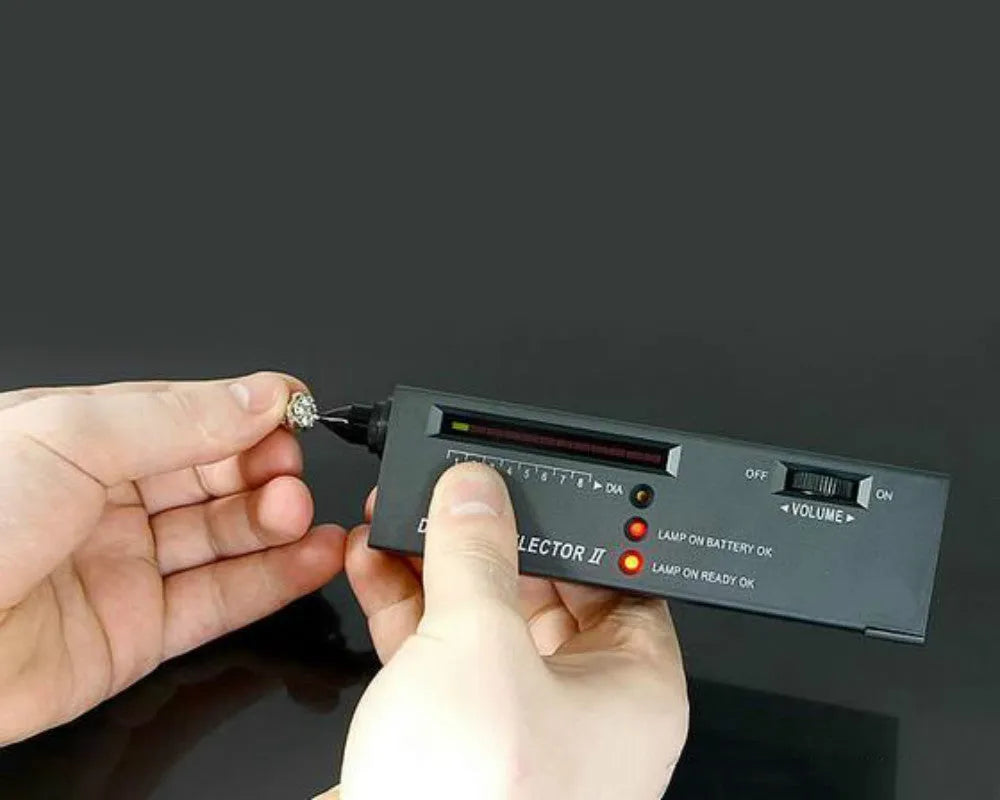 Black handheld Diamond Thermal Conductivity Tester with metal probe on a dark surface.