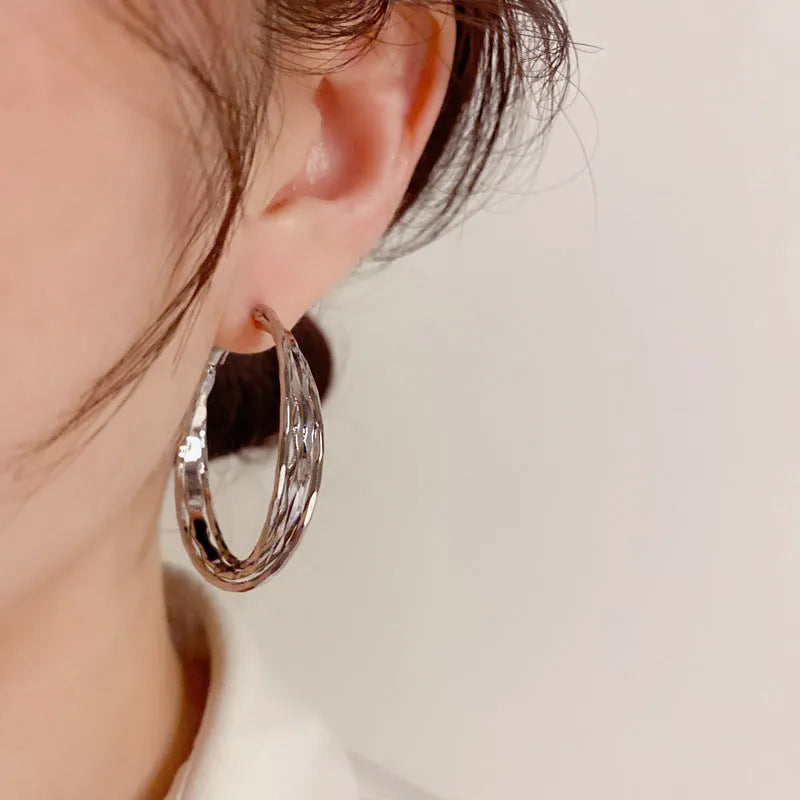 Gold metal twisted earrings with round geometric shape on copper base