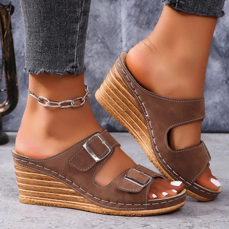 Women's creamy-white beach slippers with a black outer wedge belt buckle closure on a rubber sole.
