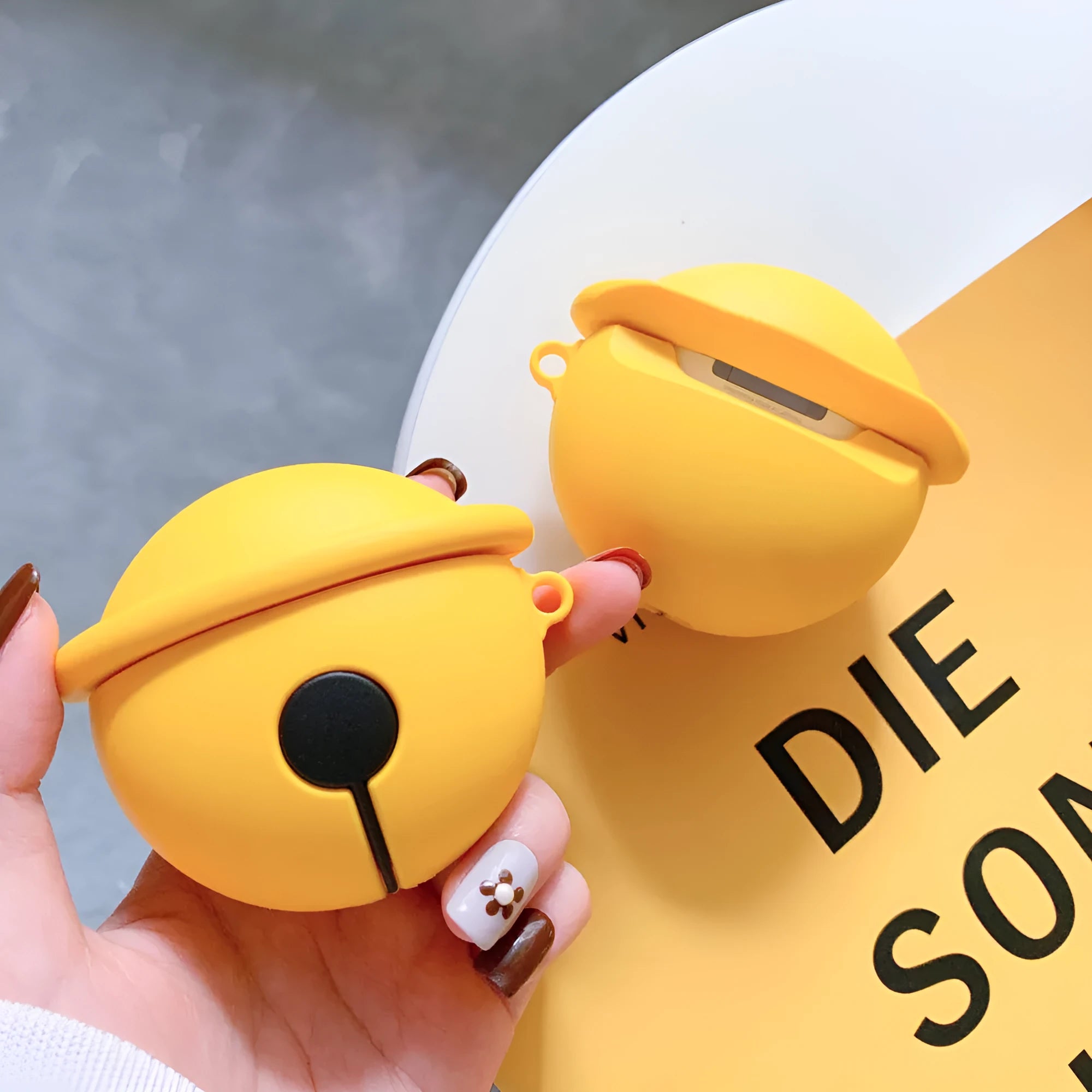 Yellow silicone AirPods case with bell charm for 1st and 2nd generation models