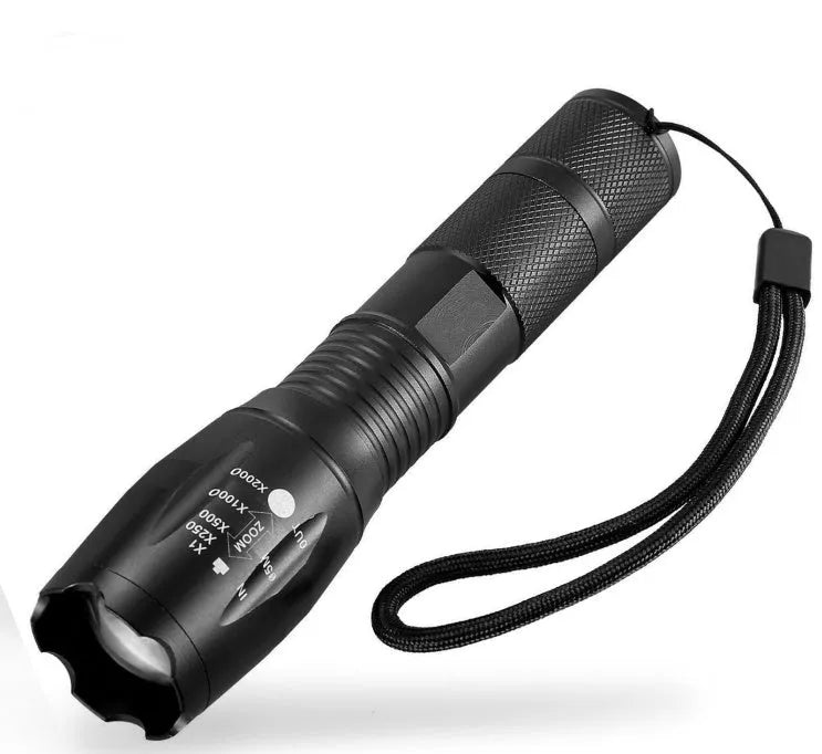 Black aluminium zoom flashlight with adjustable focus ring, shown next to an 18650 battery.