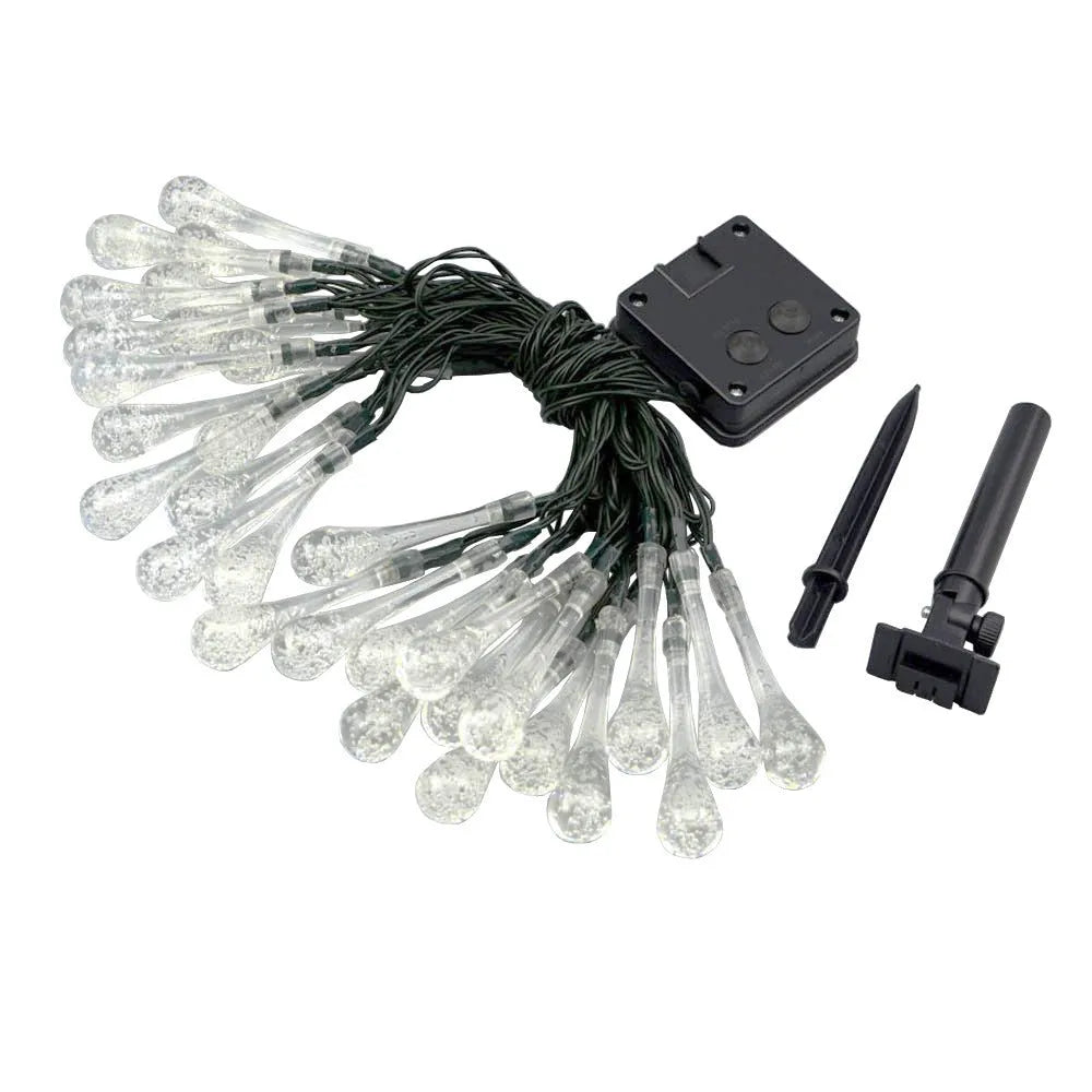 String of solar-powered bubble drop LED lights with a solar panel and ground spike for outdoor garden use.