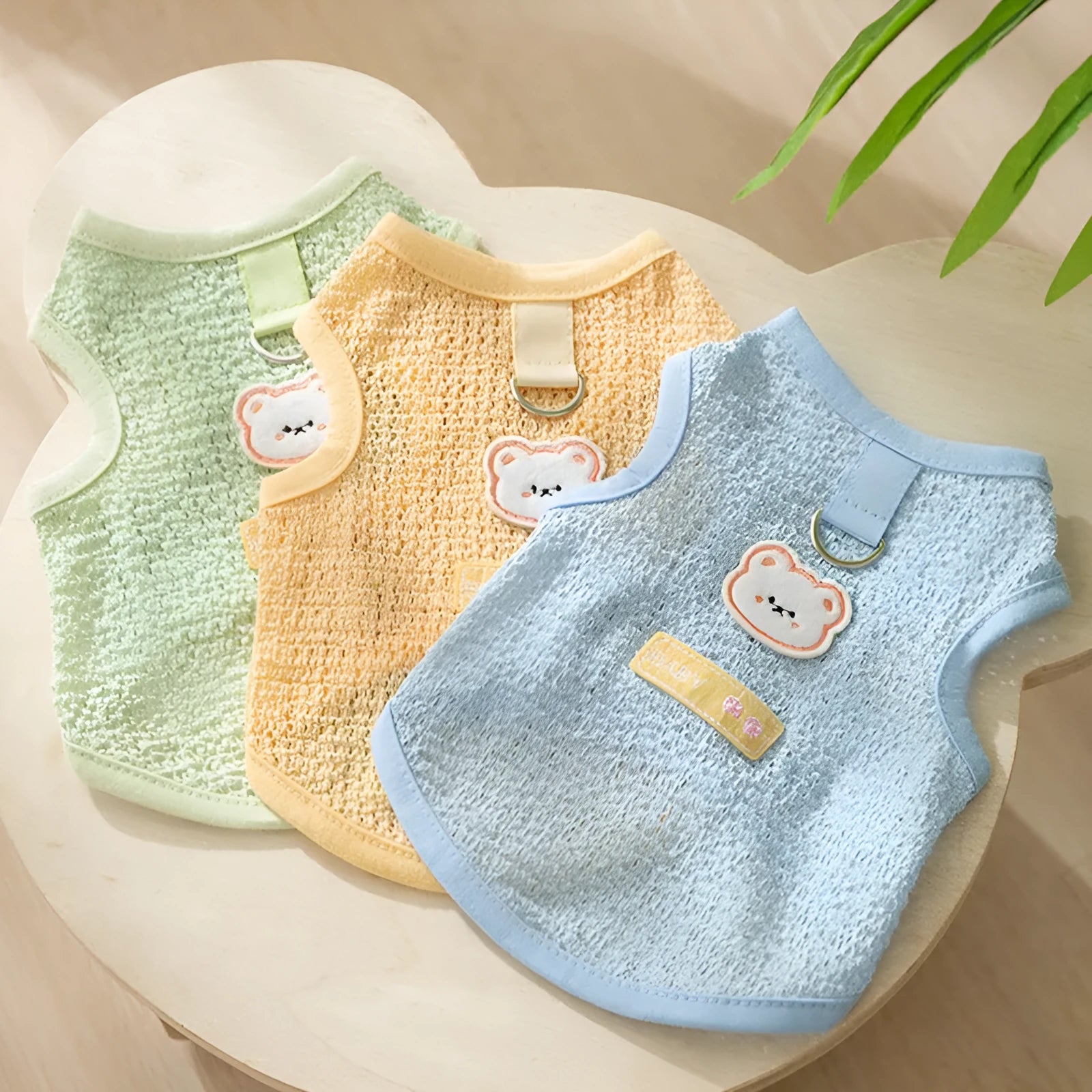Colourful hollowed-out knitted cat clothing with a cartoon bear patch on the back