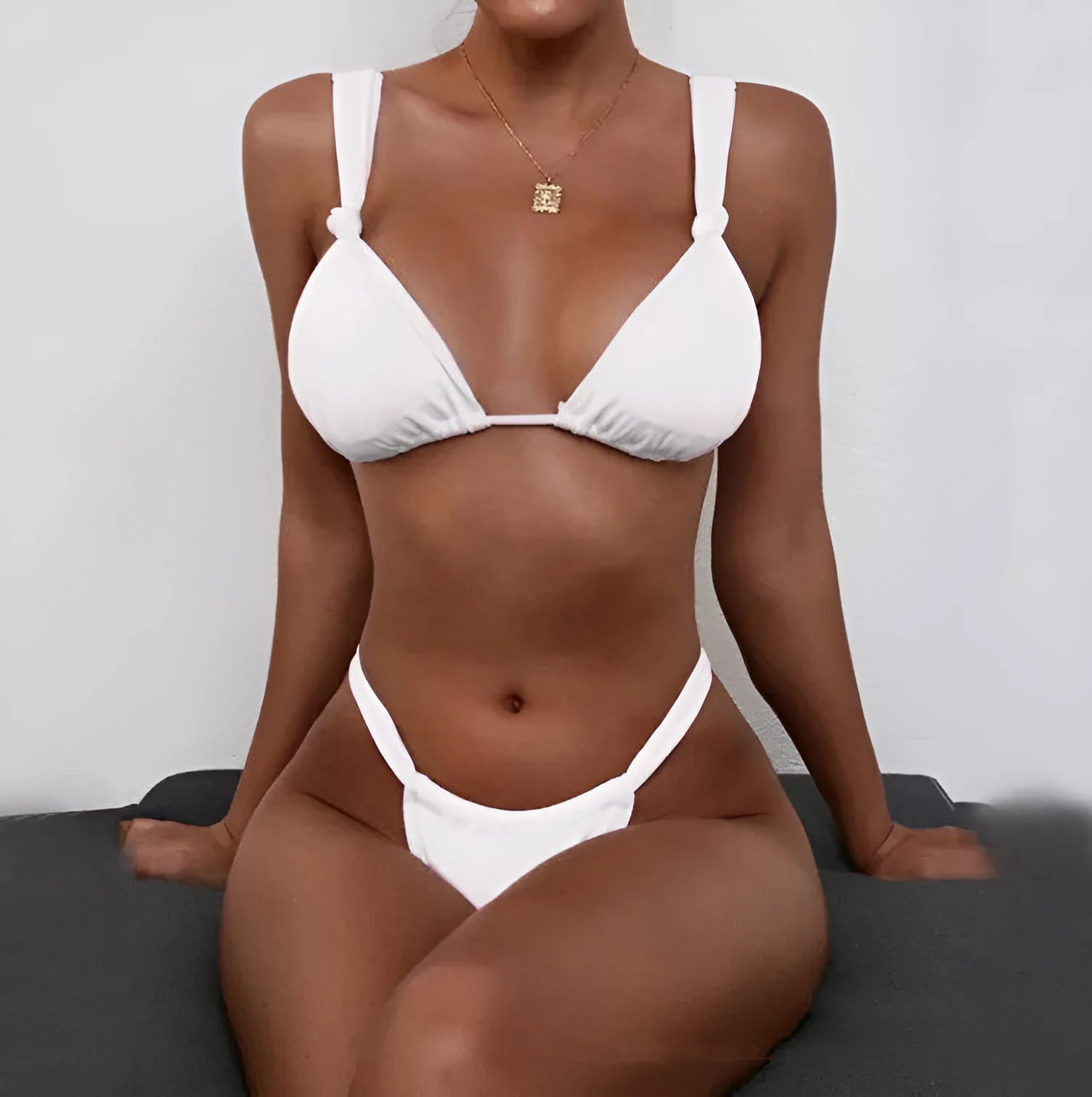 Women's pink bikini swimsuit with pleated split strap and knot detail on a mannequin
