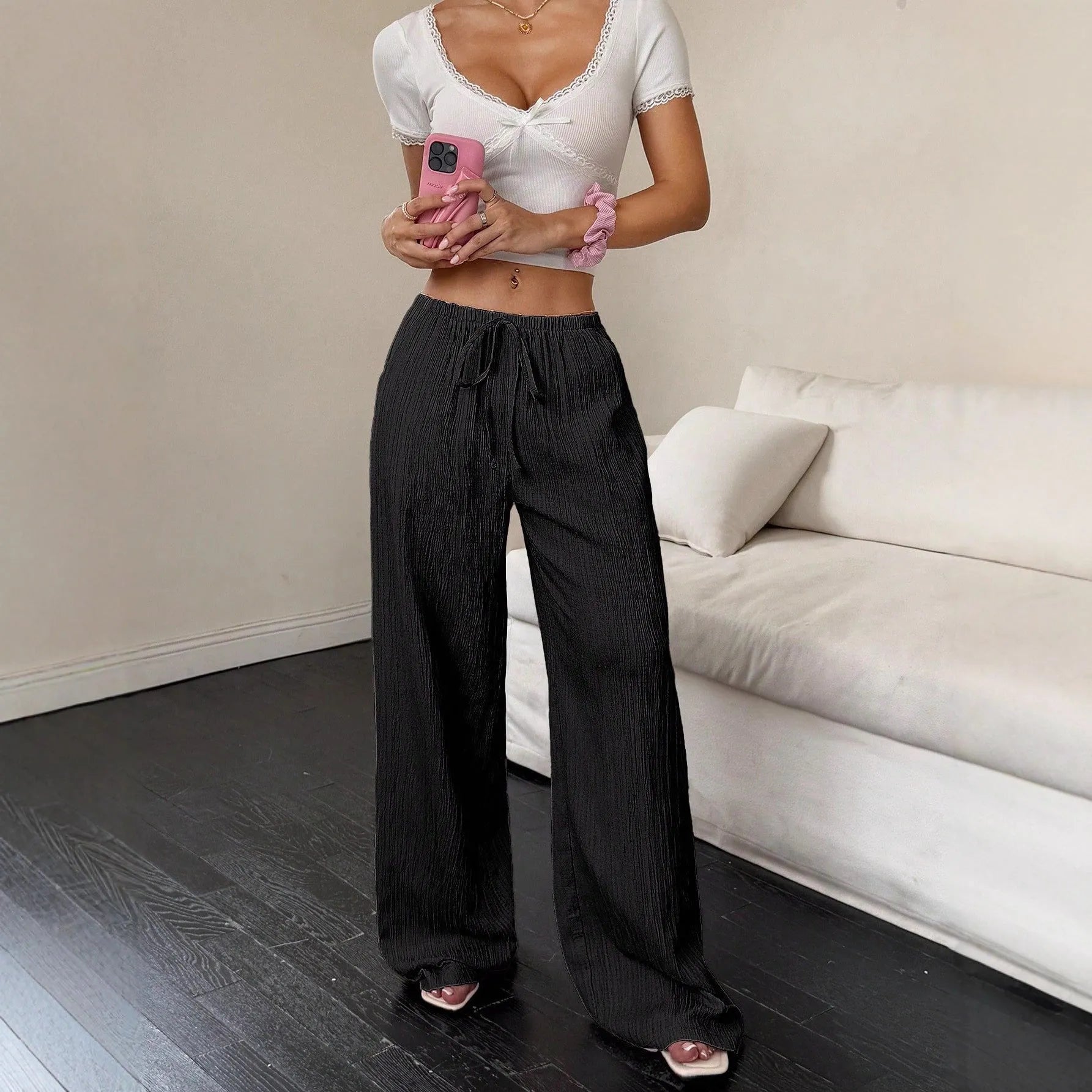 Women's black wide-leg trousers with lace-up waist detail on hanger