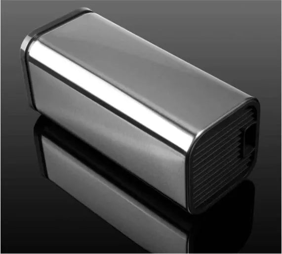 Black stainless steel kitchen tool holder with detachable base next to knives and cutlery
