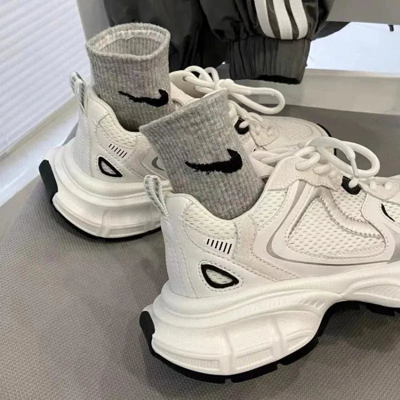 Beige mesh platform sports shoe with a wedge heel and front lace-up design on a white background.
