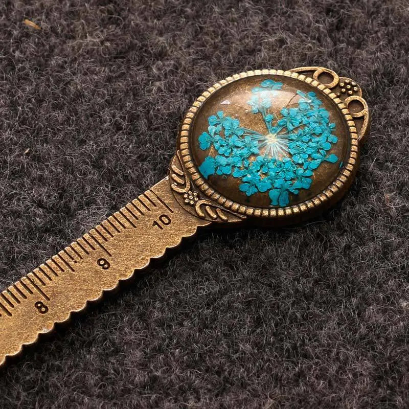 Handmade dried flower bookmark ruler with gypsophila, lace flowers, and clover, 12cm long on a book page.