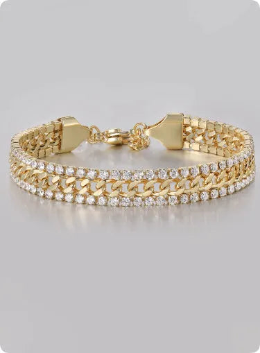 Gold coloured hip hop style tennis bracelet with chain links and artificial gemstone inlays on a wrist.