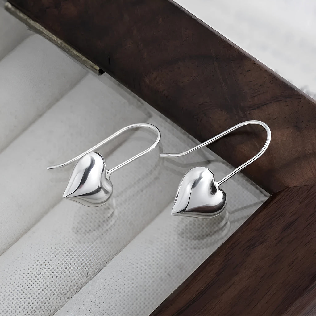 Silver heart-shaped earrings with glossy finish and ear hook fitting
