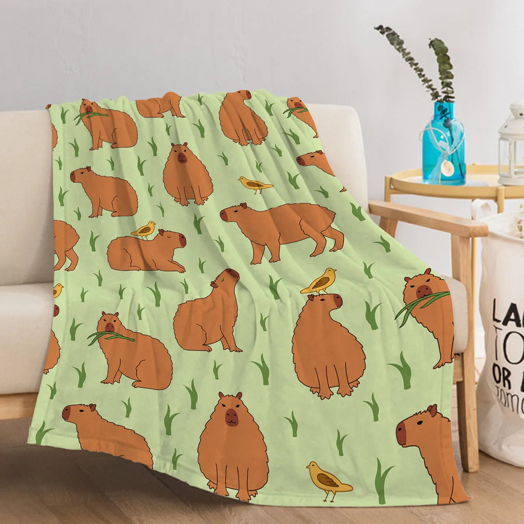 Multicolored flannel blanket with bird and capybara combined pattern on a sofa
