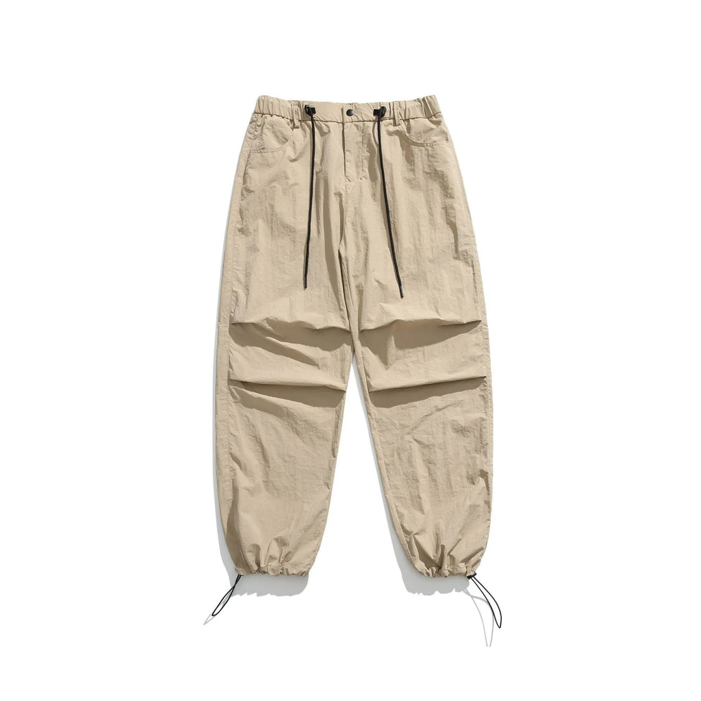 Man wearing loose straight leg casual trousers in lightweight nylon fabric, available in multiple colours.