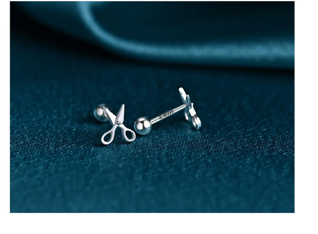 A pair of pure silver screw style ear nails with a miniature scissors design
