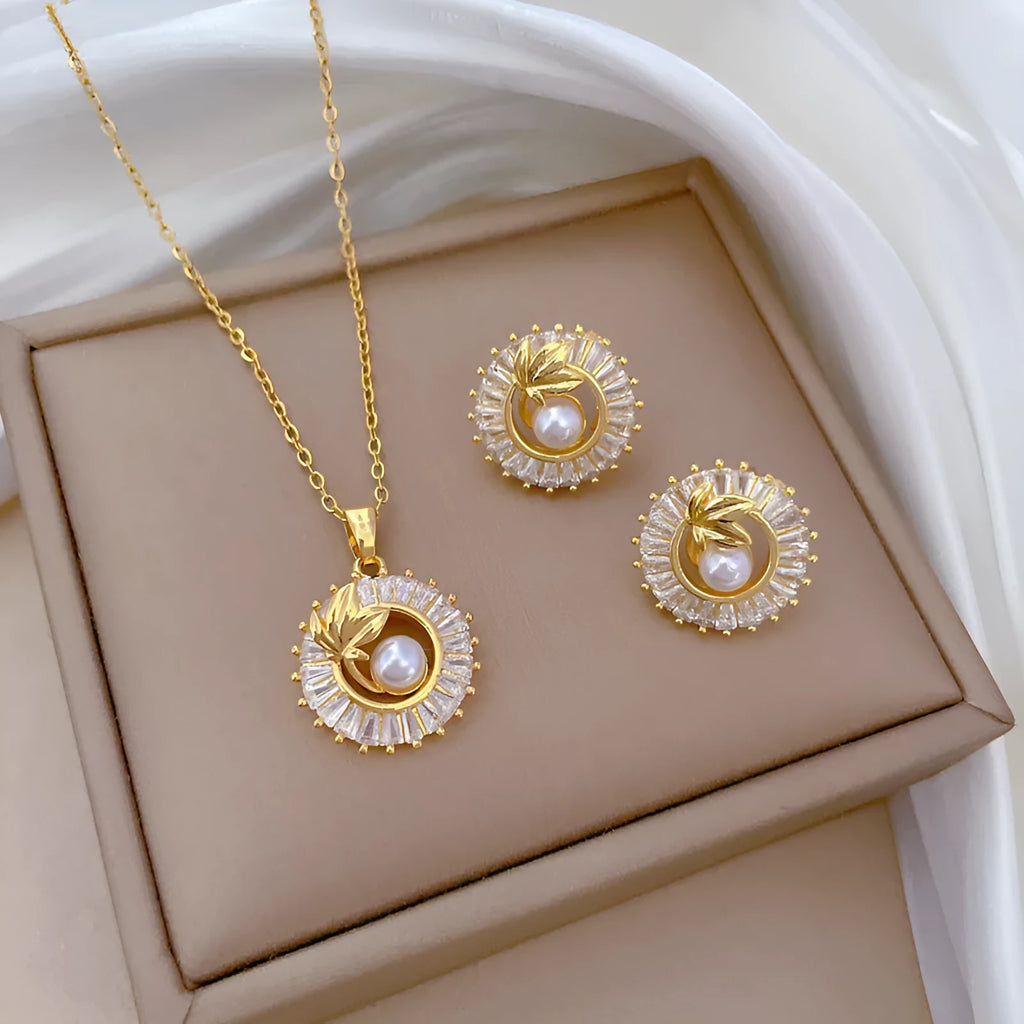 Women's geometric jewellery set with square diamond accents, ring and leaf motif on necklace and matching stud earrings.
