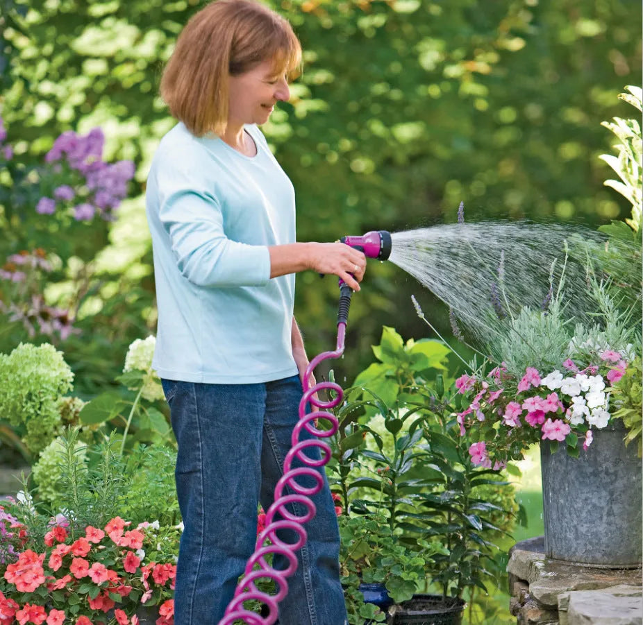 Garden telescopic hose sprinkler with ABS gun head extended on a lawn