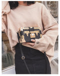 Hard structured black PU leather women's shoulder bag with decorative rivets and single adjustable strap