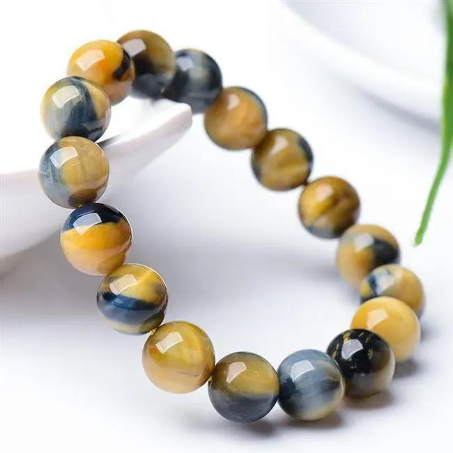 Handmade Fantasy Tigereye agate gemstone bracelet with round beads on a wrist.