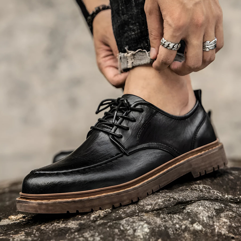 Men's black casual leather shoes with a round toe and flat rubber sole on a white background