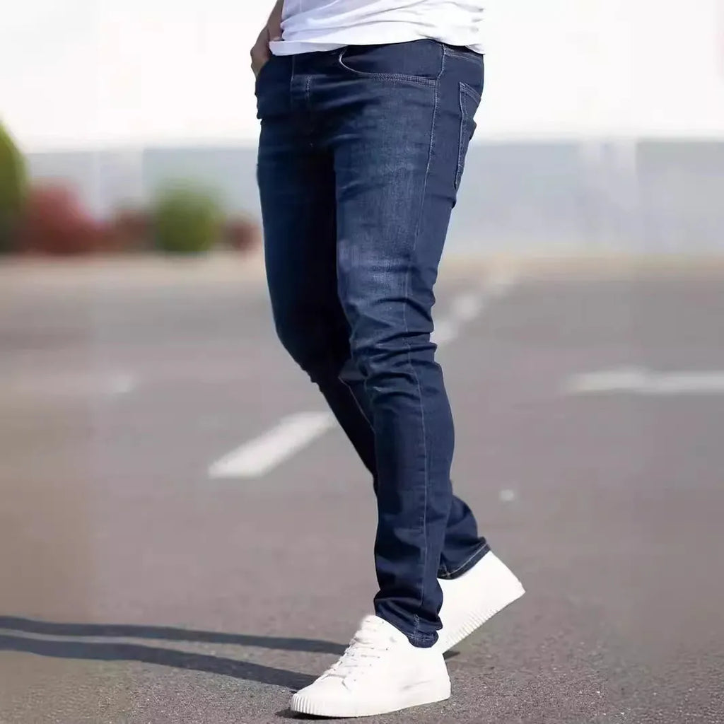 Dark blue men's skinny jeans with a mid-waist fit and zipper fly, laid flat.