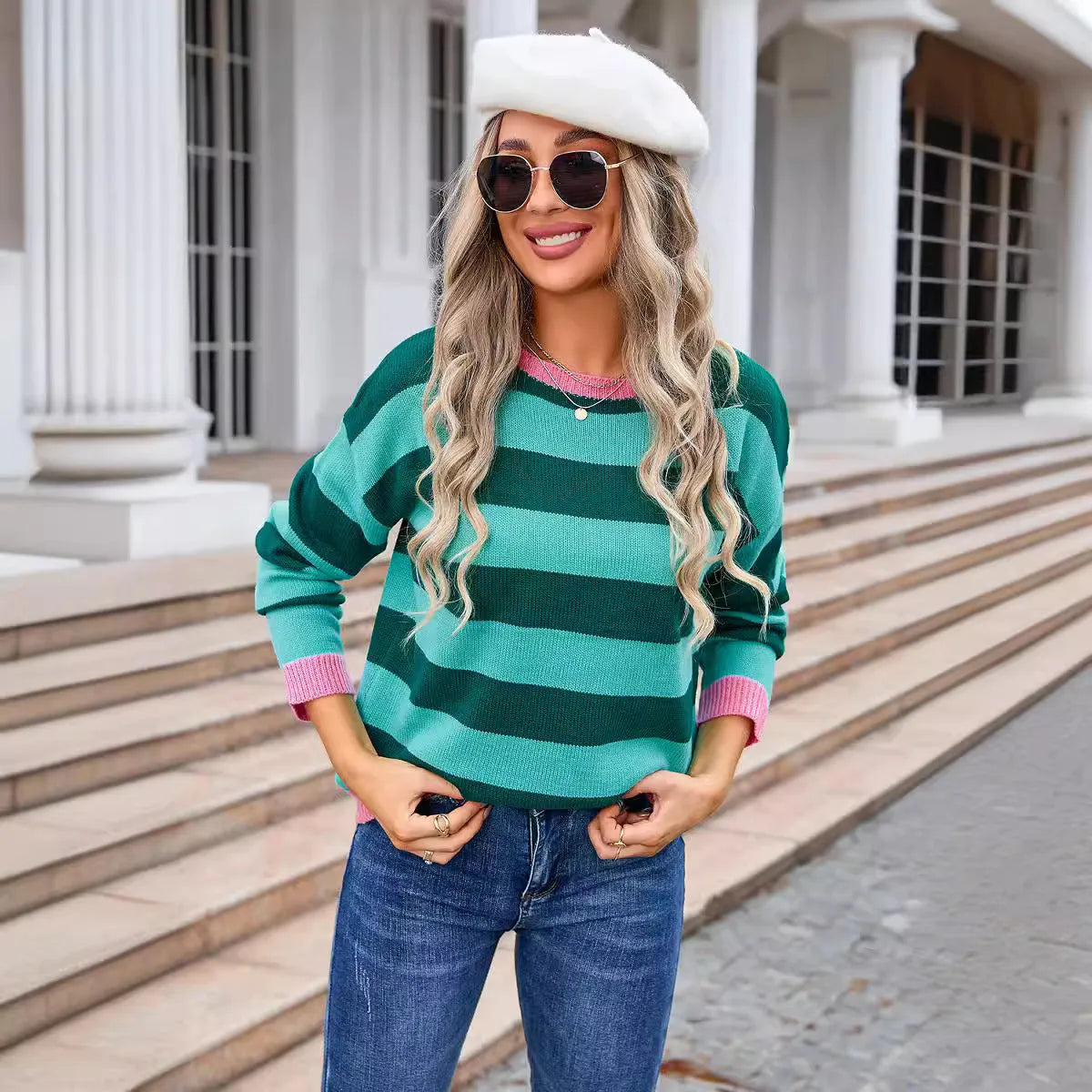 Women's loose blue acrylic knit sweater with round neck and long sleeves on a hanger.