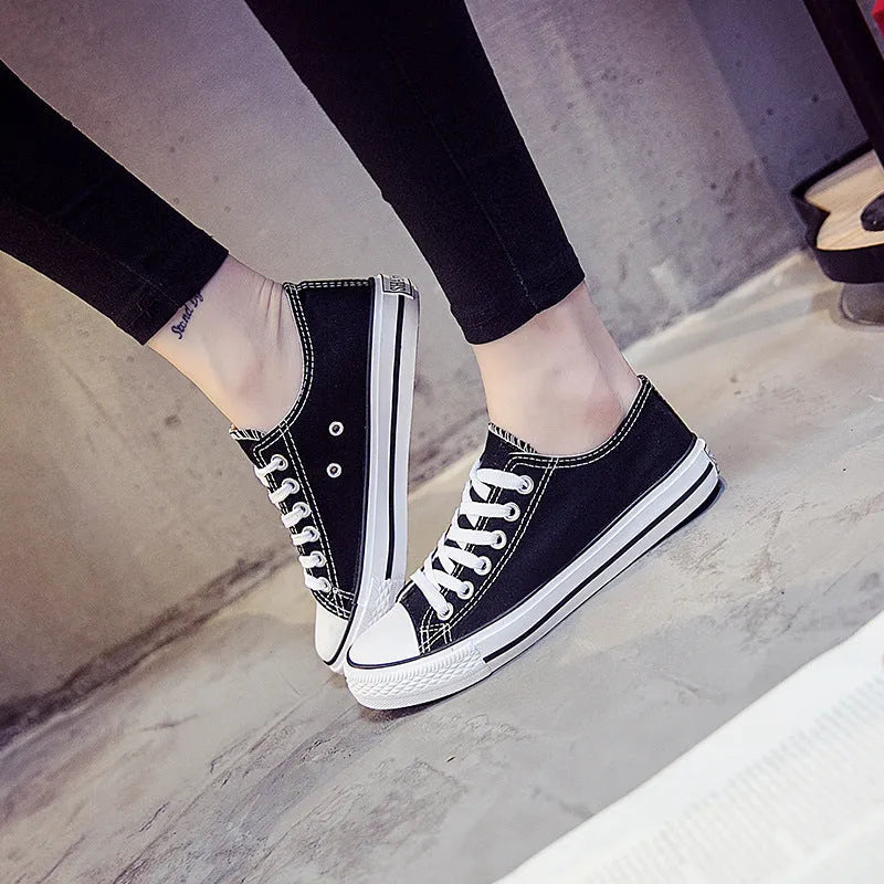 Women's casual canvas shoes in solid colours on a flat sole, showing lace-up fastening.