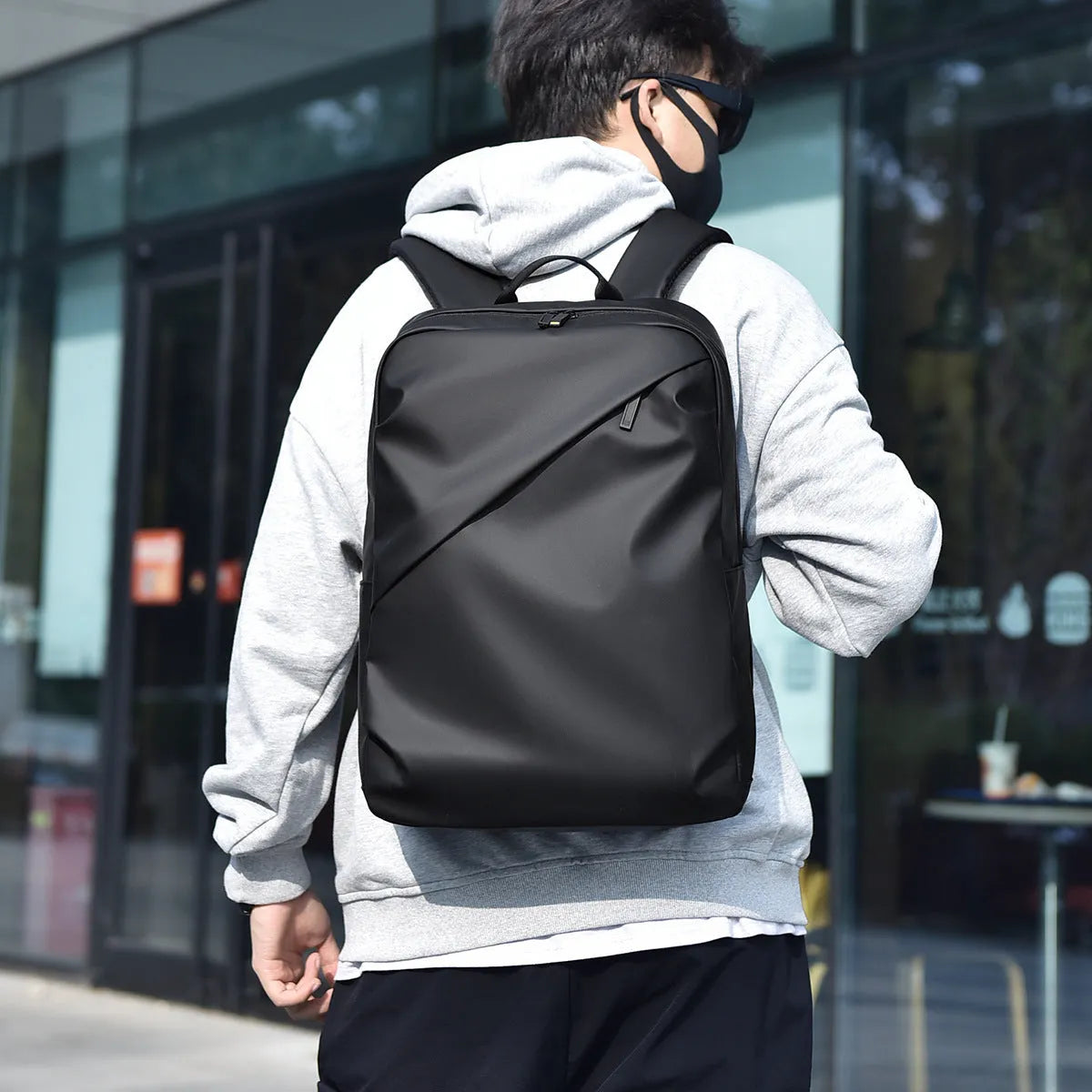 Men's large capacity waterproof backpack in black colour showing PU leather construction and computer bag accommodation