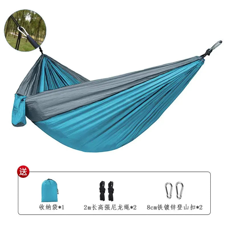 Blue parachute cloth camping hammock hung between trees showing 270cm length