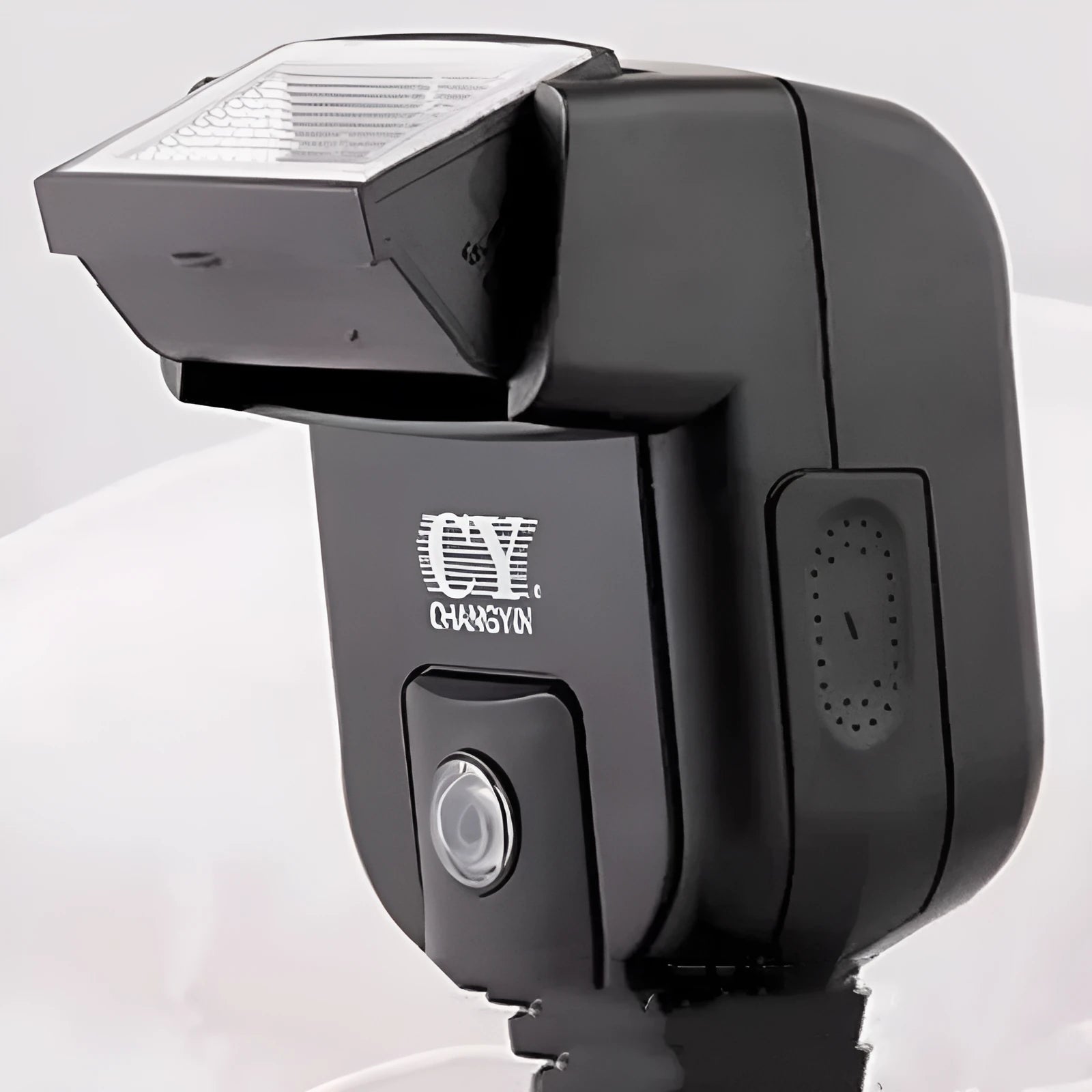 A compact black hot shoe flashgun for DSLR cameras, shown tilted upwards on its mount.