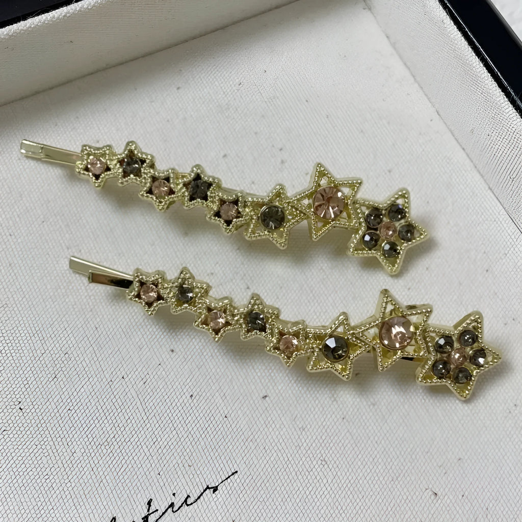Gold electroplated rhinestone barrettes with side clip design featuring star and letter charms