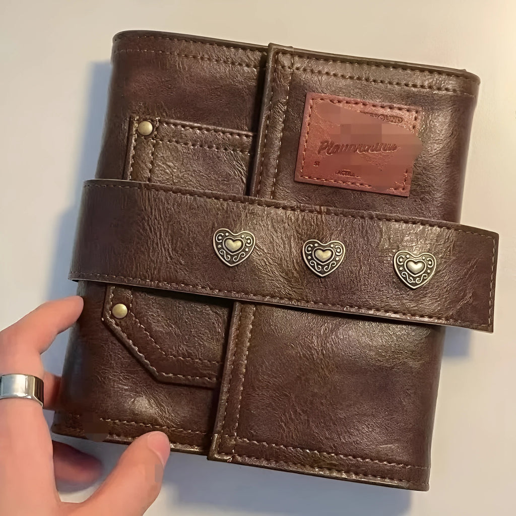 Brown A7 PU leather buckle notebook with loose-leaf binder binding on wooden surface