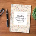 A5 weekly pregnancy diary notebook open to show weekly tracking pages