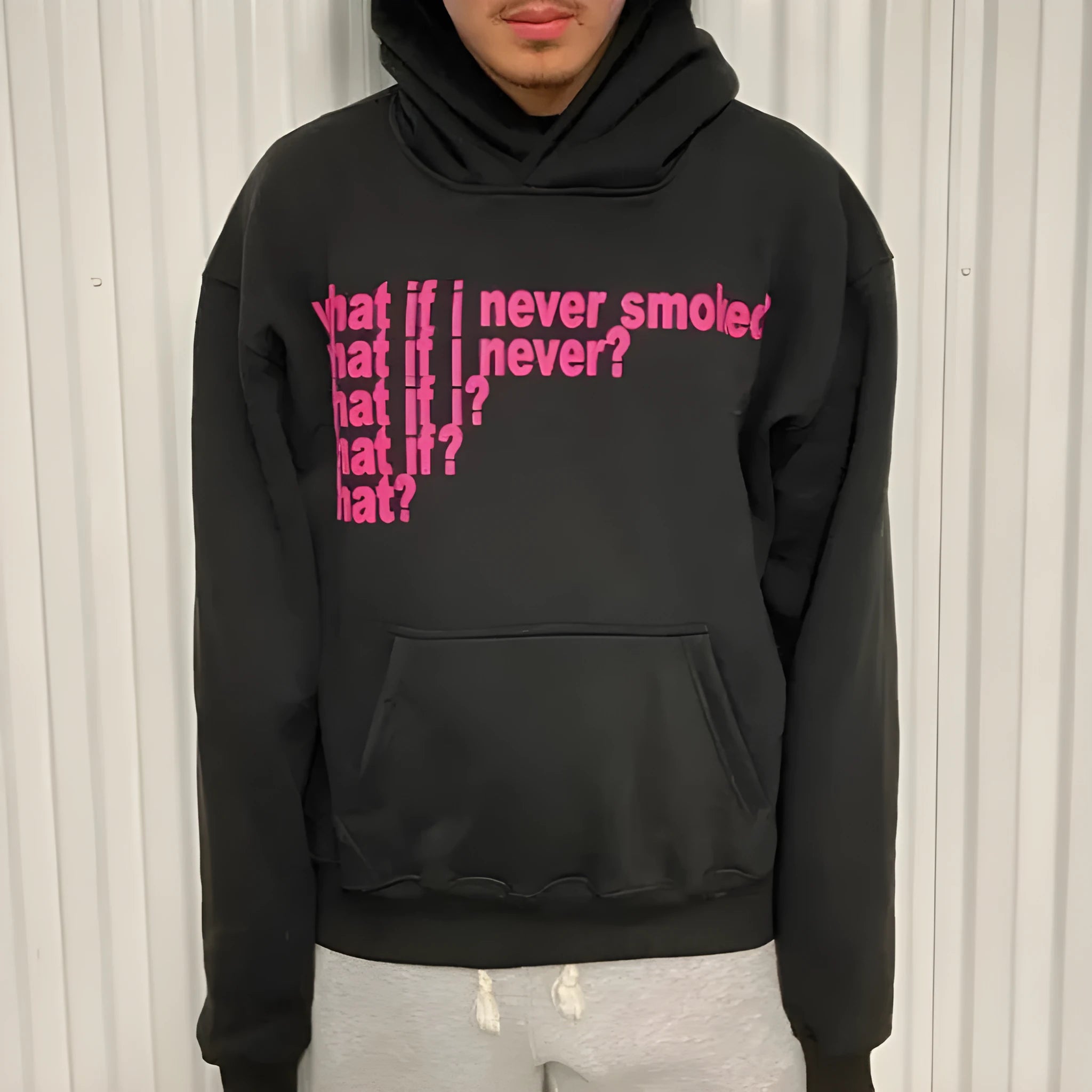 Black hooded sweater with white letter print on the front, shown on a model.