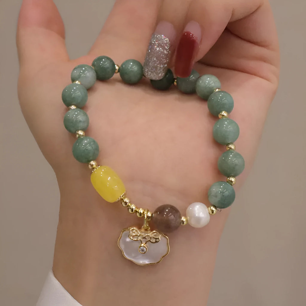Green jade beaded bracelet with a silver-toned shell charm on an adjustable black cord.
