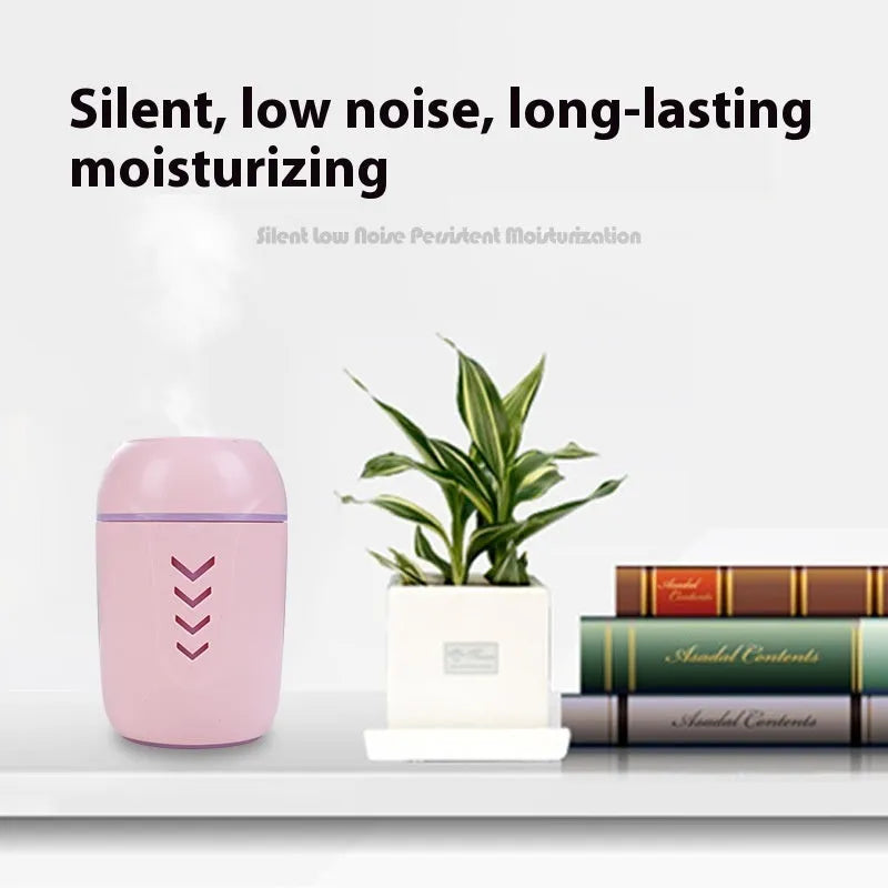 Round blue portable air purifier and aromatherapy diffuser unit with USB cable on a wooden desk.