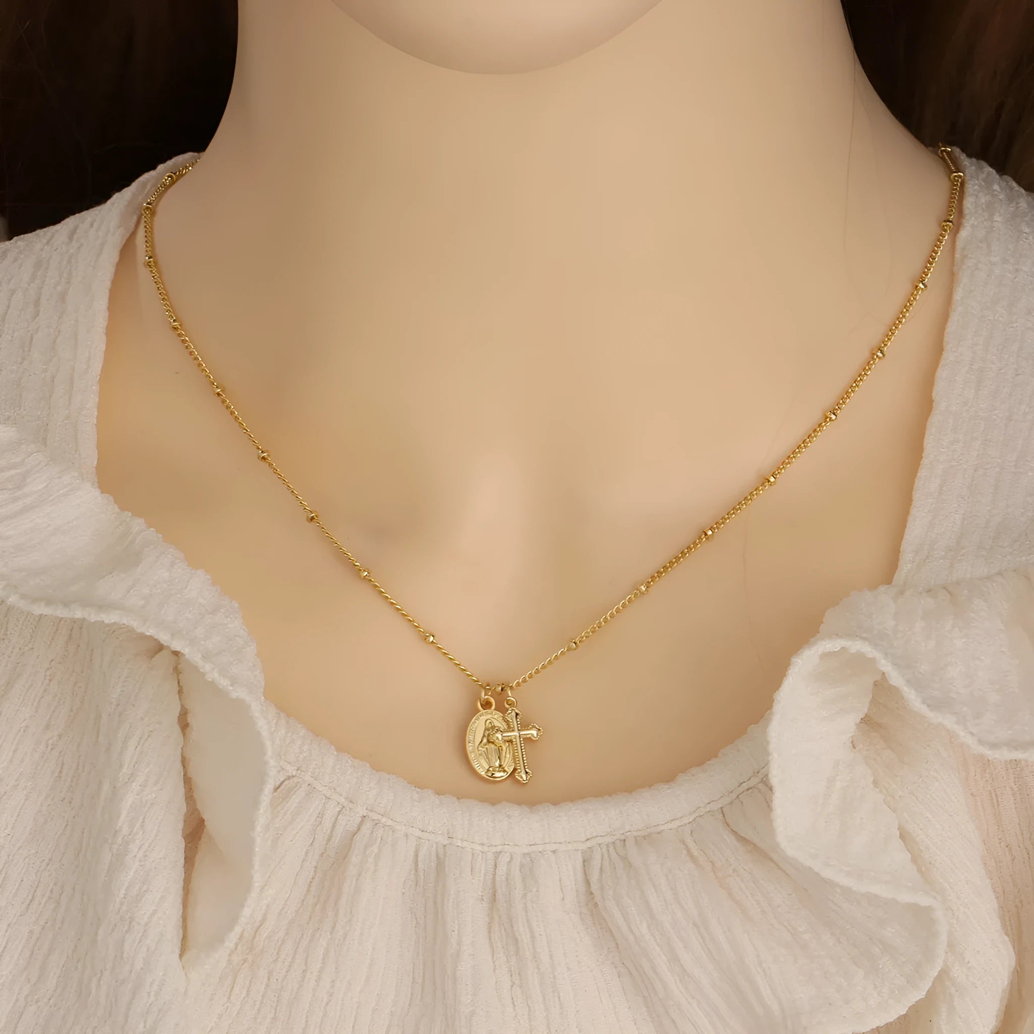 Geometric Virgin Mary and cross pendant necklace in 18K gold colour on a copper chain.